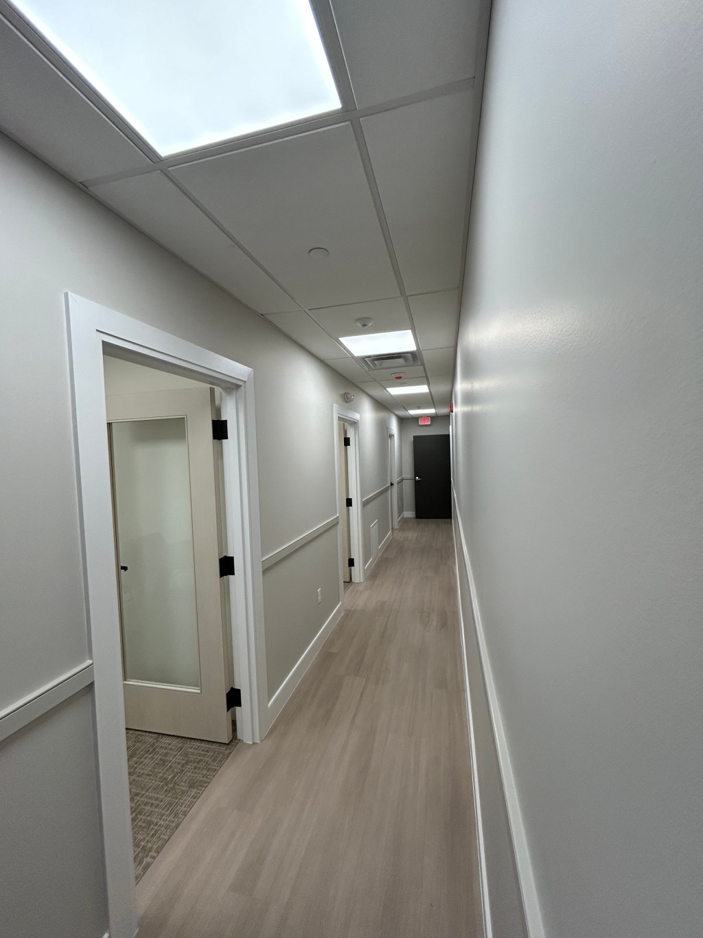 Finished office corridor with new flooring, chair rail and frosted glass doors