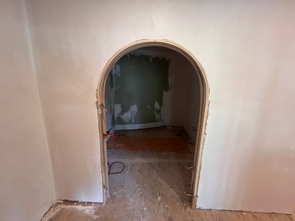 Curved wood casing being glued up on an arched doorway